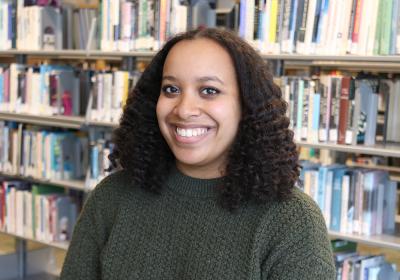 Semira Mesfin in front of stacks at Minneapolis Central Library