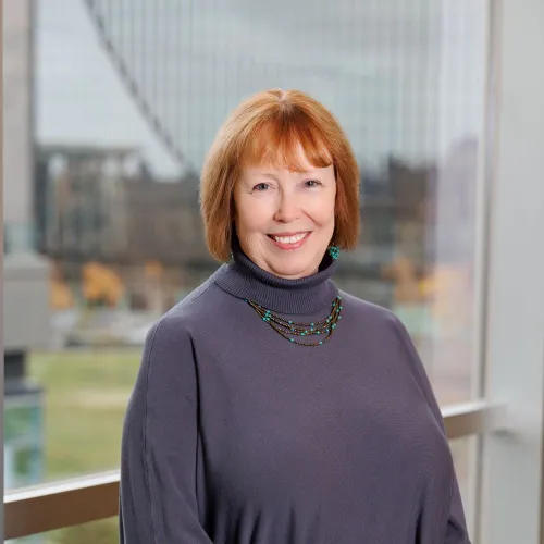 Portrait of Linda Merritt in front of the stacks at Minneapolis Central Library