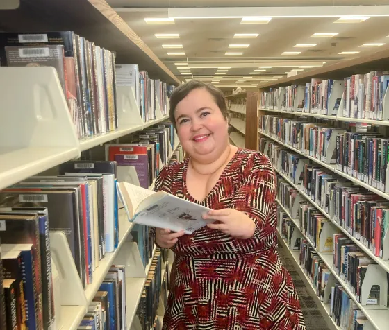 Senior Librarian Tami poses among the stacks at Ridgedale Library.