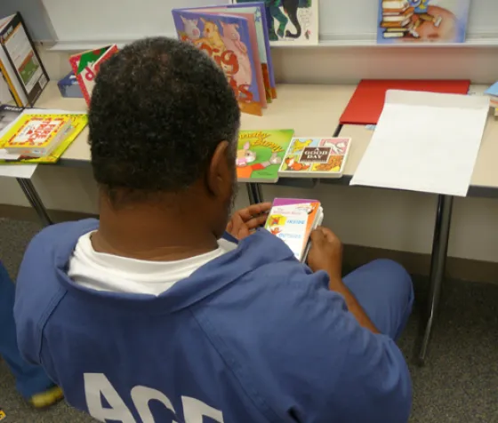 ACF resident inspects children's books during the Read to me Program.