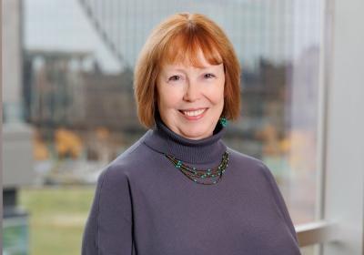 Portrait of Linda Merritt in front of the stacks at Minneapolis Central Library